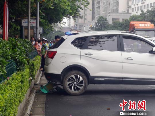 汽车后轮位置有一辆已经变形的婴儿车。 朱柳融 摄