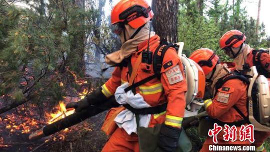 图为消防人员扑救现场。 高飞翔 摄