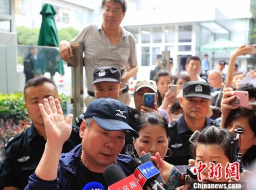 图为受害者父亲在法院外接受采访。