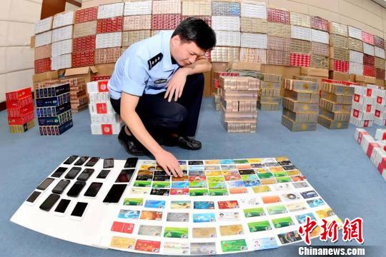 图为涉案银行卡、手机等。海南省公安厅供图