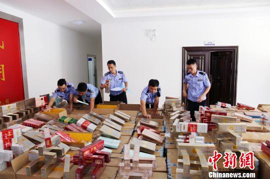 图为民进对查扣的走私烟、假烟进行清点登记 代龙超 摄
