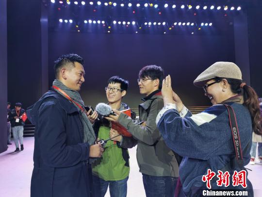图为西藏自治区庆祝中华人民共和国成立70周年文艺晚会总导演白玛次仁(前排左一)接受记者采访。 何蓬磊 摄