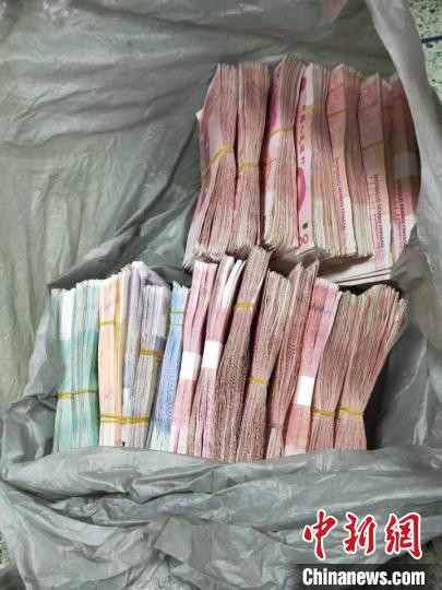 民警从犯案男子包中搜得的现金。 供图 摄