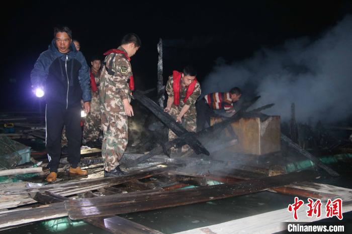 海警人员协助渔船民清理火灾现场。 赵天然 摄