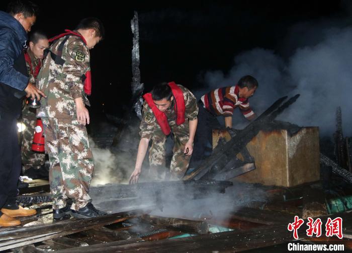 海警人员协助渔船民清理火灾现场。 赵天然 摄