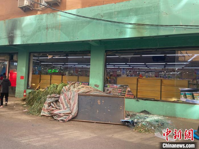 附近商铺的牌匾被震落。 王景巍 摄