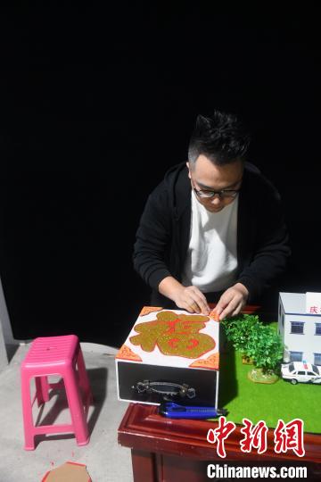 秦国平为今年的春运首日宣传活动制作魔术道具。 蒋雪林 摄