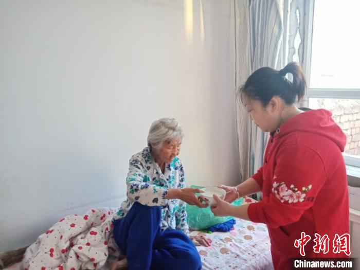 图为宋敏照顾老人吃饭。 宋敏供图 摄