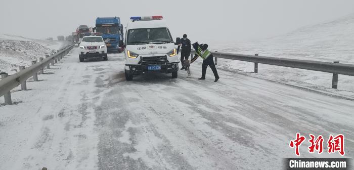 图为4月22日,西藏安多县公安局民(辅)警联合公路养护部门在国道109线唐古拉山路段抢通道路,帮助过往司乘人员。安多县公安局 供图