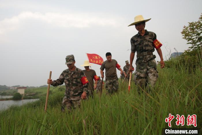 江西上饶市余干县枫富联圩堤坝上,“大溪乡民兵应急排”在巡堤排险。 王成前 摄