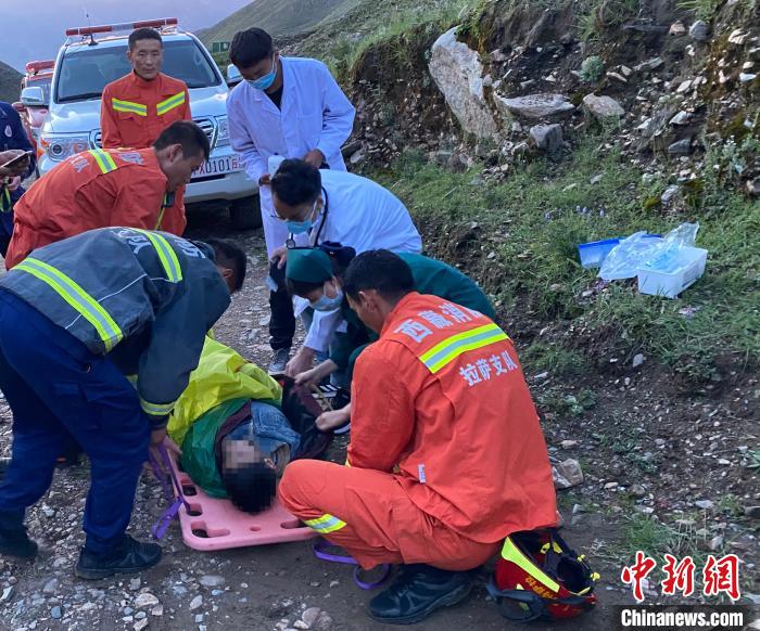 图为救援力量成功将被困男子转移至山脚位置并移交医护人员。拉萨消防 供图