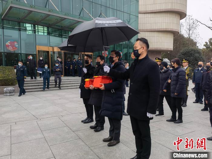 至亲家属手捧骨灰步入风荷园。