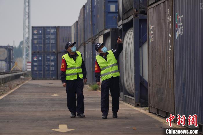 陆义章、林忠明对货场进行巡逻检查。 张一凡 摄