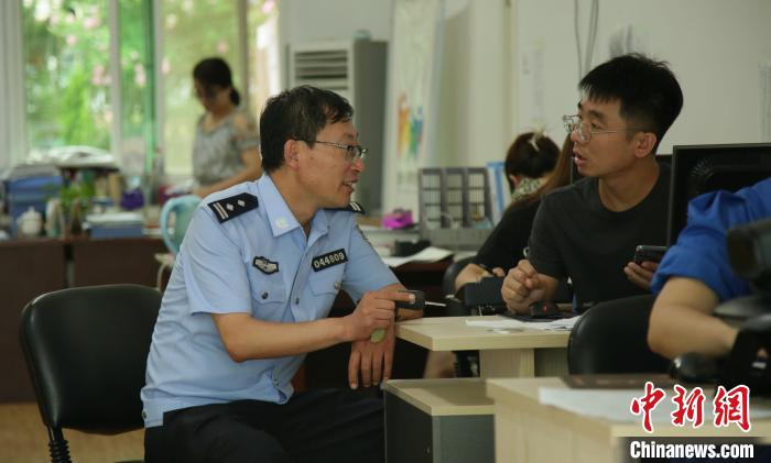 王广极与社区工作人员交流。 丁雷 摄