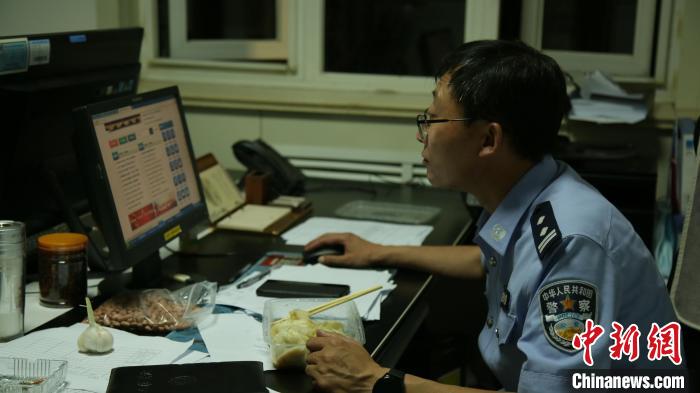 出警回来的王广极边工作边吃饭。 丁雷 摄