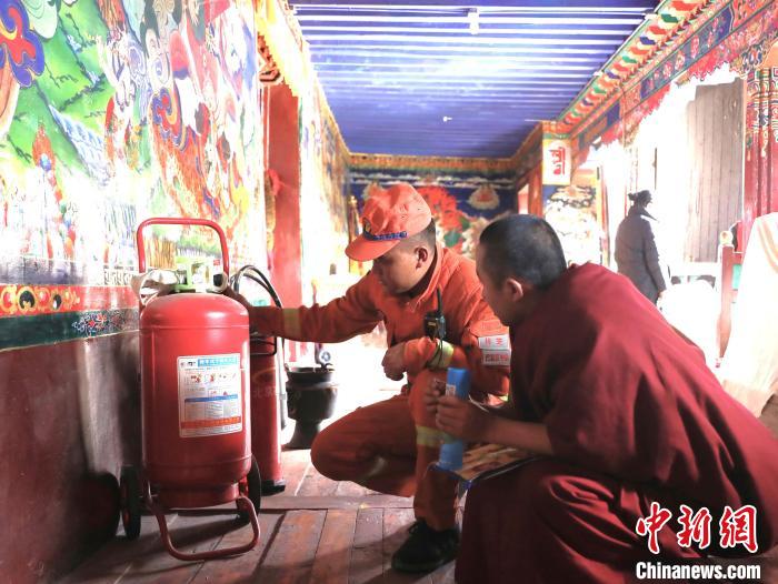 森林消防队员为僧人讲解灭火器使用方法。 西绕拉翁 摄